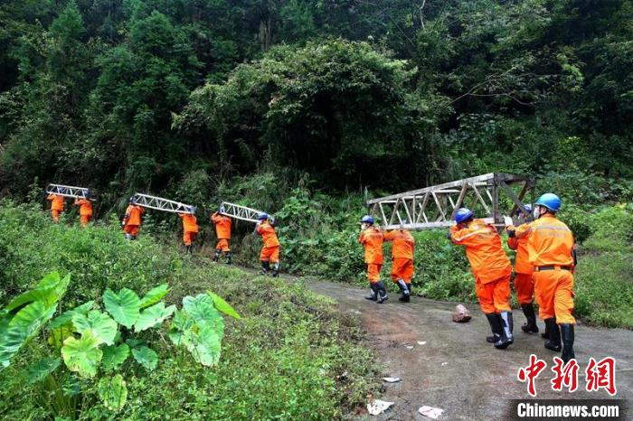 电力抢险人员正在搬运铁架。王鸿基 摄
