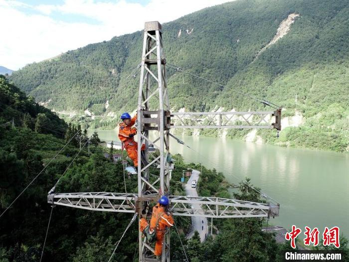 电力抢险人员正在加紧组立应急铁塔。王鸿基摄
