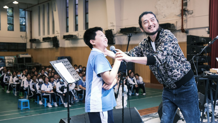 康磊在校园里与学生互动。（采访对象供图）