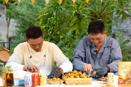 　　林丹与果农杜礼才进行剥刺梨比拼