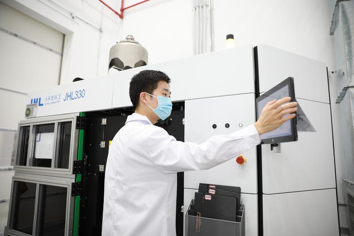 季华实验室青年科技工作者饶衡博士正在操作3D打印设备进行实验。佛山日报记者 张弘弢 摄