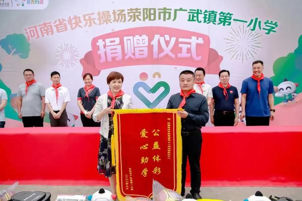  荥阳市广武镇第一小学校长朱伟委（右）向河南省体育彩票管理中心主任王海新（左）回赠锦旗