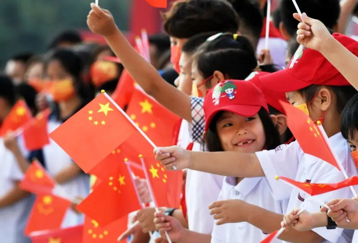 资料图：2021年10月1日，市民在青岛举行的国庆升旗仪式上挥舞国旗。新华社记者 李紫恒 摄