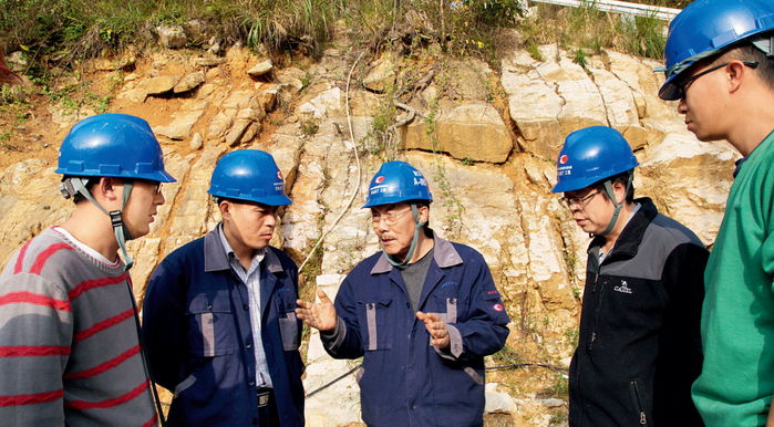 南仁东（中）与工程技术人员在大窝凼施工现场检查施工进展（2014年12月1日摄） 中科院国家天文台供图