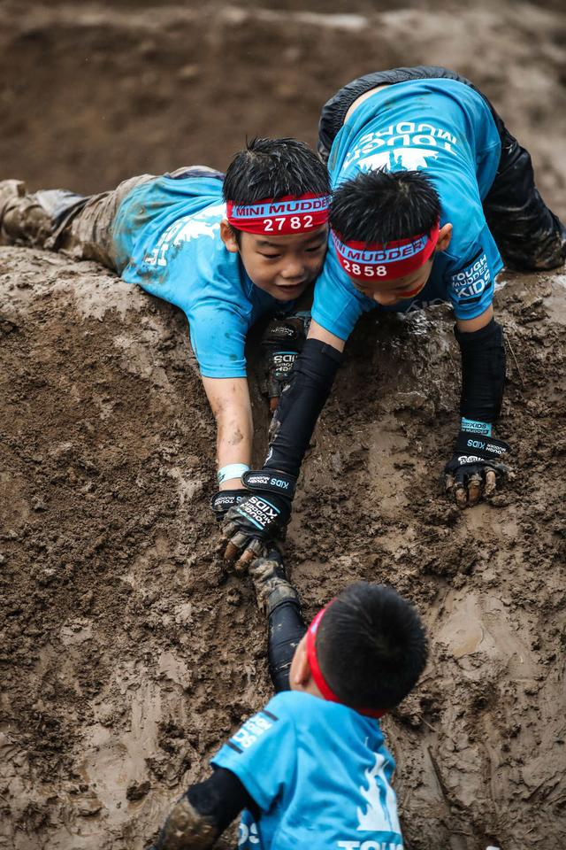 参赛选手互相协助爬出泥坑。  主办方供图