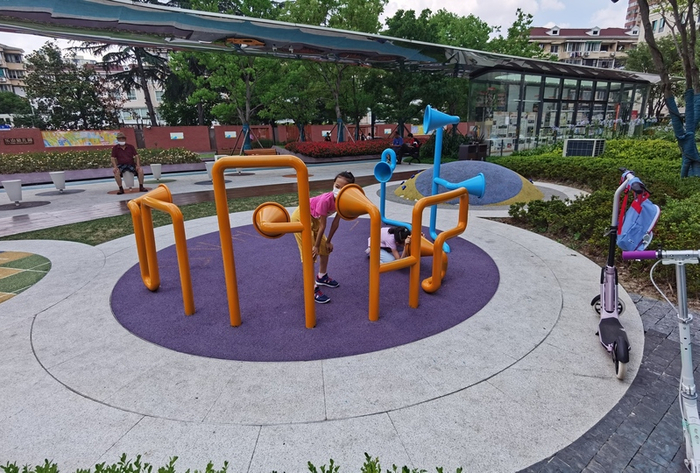 乐山绿地，孩子玩耍时，大人可以坐在一旁的弹簧灯柱上  陈玺撼 摄