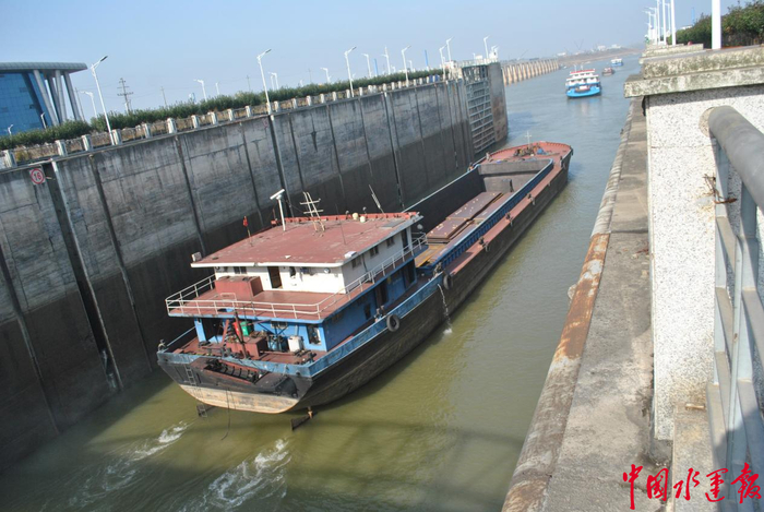 图为2017年12月16日,枯水期载货船舶过闸下驶。