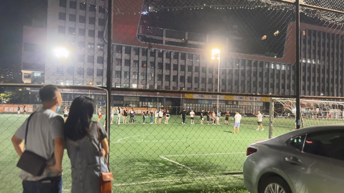 深圳车公庙，一对情侣围观时下流行的飞盘游戏（陈彦洁摄）