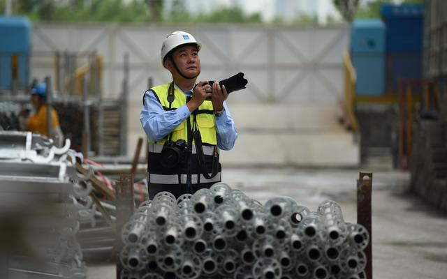 工作之余，倪修龙去工作一线为城市建设者们拍照。受访者供图