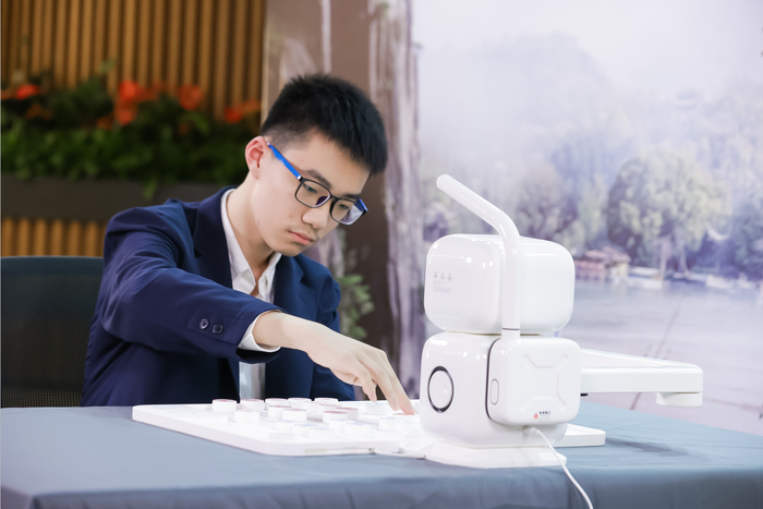 　　青少年象棋冠军顾博文与“元萝卜SenseRobot”AI下棋机器人对弈