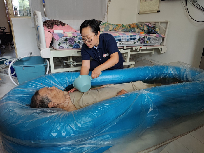 助浴师正在帮老人洗澡。受访者供图。