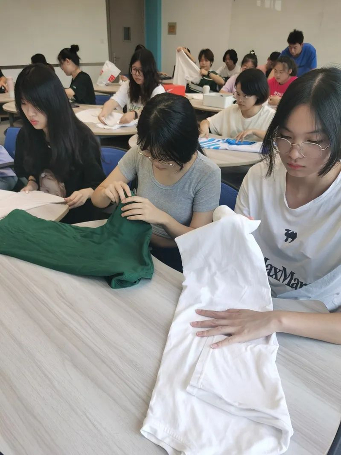 家政学专业的学生们在实践课上学习衣物的整理与收纳。