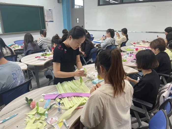 授课教师彭玮正在指导学生们做纸花。