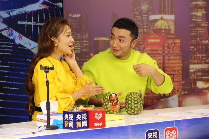 ▲  央视主持人朱迅（左）与小尼（右）正在讲解产自菲律宾的金菠萝。张伟 ▏摄