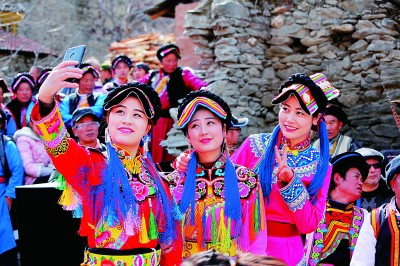     茂县的羌族女子在集会上拍照 雷建摄