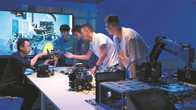 　　深信院与腾讯、商汤等知名企业深化合作，共建课程、共育人才，图为学校软件学院教师给学生讲解企业无人车的构造原理;