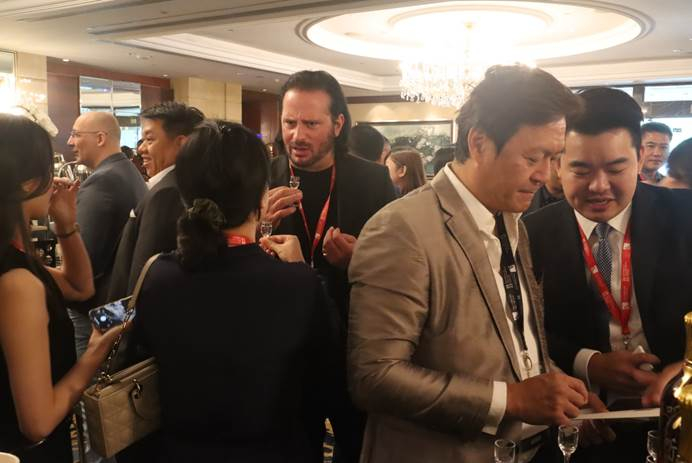 　　图为11月21日，2022商业与慈善国际论坛上，与会者在品鉴听花酒时与品牌团队交流感想