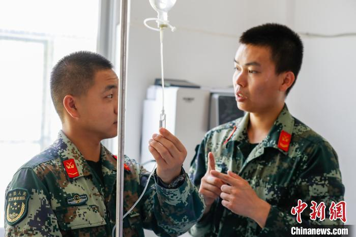 图为张坤博（右）向卫生专业学兵传授技能。蔡云祥摄