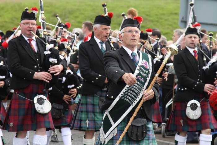 2014年6月28日，在英国苏格兰斯特灵，苏格兰风笛手方队在“武装部队日”庆祝活动中行进。新华社记者郭春菊摄