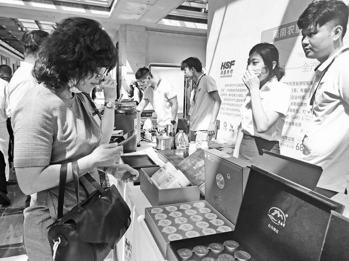     游客在展会购买白沙绿茶产品 海南农垦热作产业集团有限公司 供图