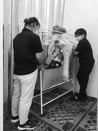 迷你仓工作人员正在将租户存放的杂物放入仓室内 黄品超 摄