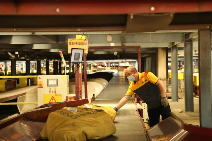 图为香河县韵达华北转运中心，工人在操控自动化分拣设备传送快件。