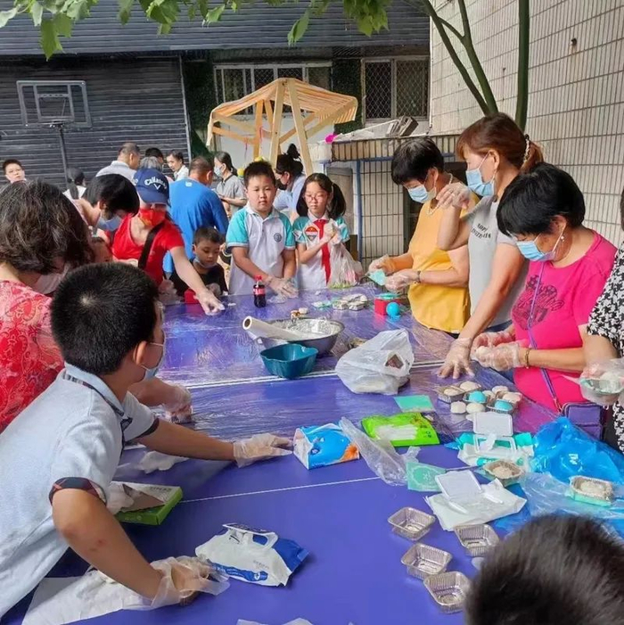 中秋节当日，东明广场的居民在运动场上制作手工月饼。  受访者供图