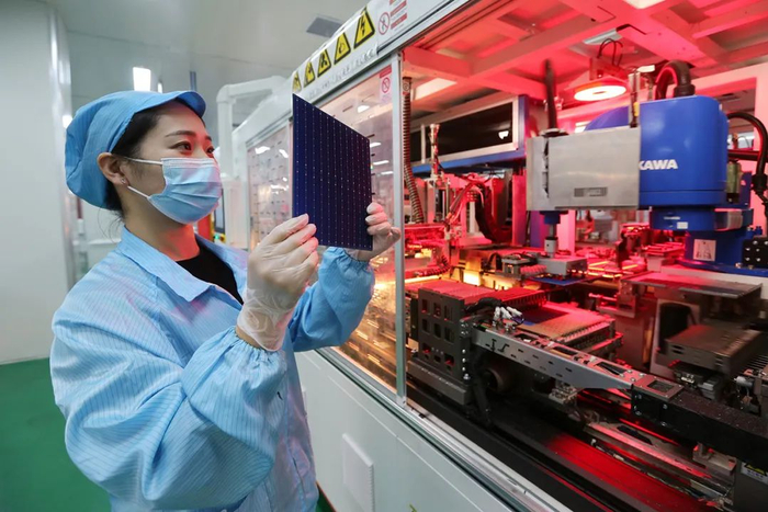 2022年11月24日，安徽省淮北市烈山经济开发区一家光伏电池生产企业车间，工人在生产线上查看产品。图｜IC photo