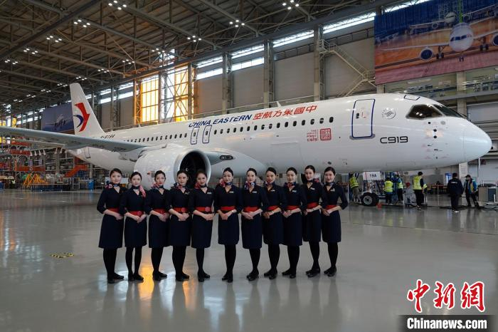 东航空乘代表与C919全球首架交付飞机合影。　中新社记者 孙自法 摄