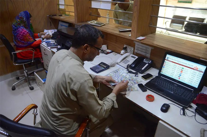 2022年5月20日，巴基斯坦卢比兑美元跌至201.30的历史低点，图为外汇交易员在清点美元