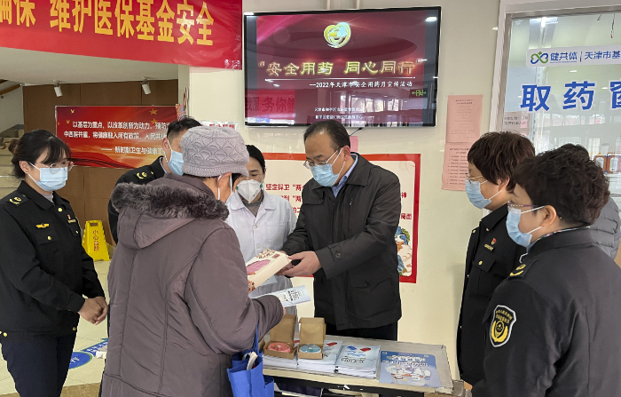 图为活动现场，该局执法人员向群众发放安全用药宣传资料。