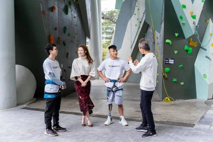 　　万科主席王石、BrainCo高级副总裁何熙昱锦与仿生腿体验官参与攀岩活动