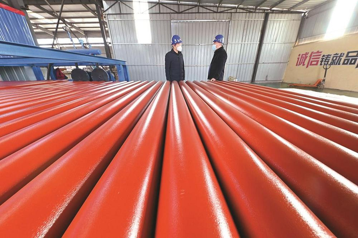         在飞翔金属制品有限公司精品车间，武安市大同镇党委书记冯帅（左一）在了解该企业产品销售情况。                                                        本报记者 胡晓华 摄