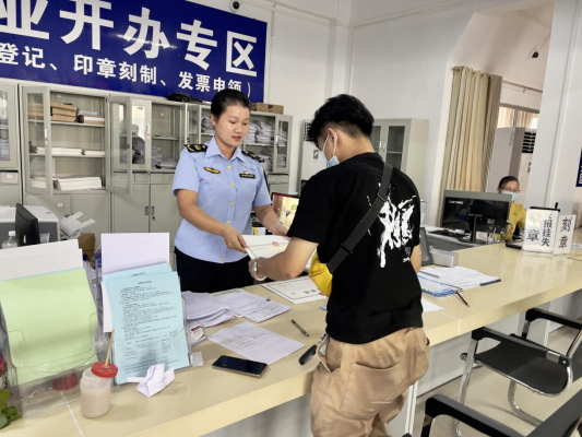 图为江州区窗口工作人员给申请人颁发个体工商户经营者变更的营业执照