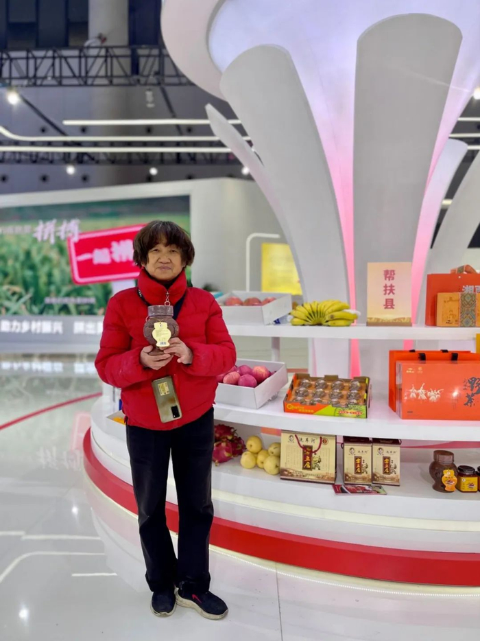 今年71岁、来自湖南省龙山县的霉豆腐非遗传承人刘金霞，带着特色产品亮相农交会拼多多展台。沙棘|摄