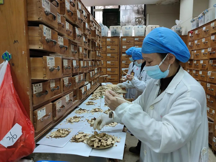 在市中医院总院中药房内，医务人员们正忙着配药分装药包、熬药分装汤剂。资料图片