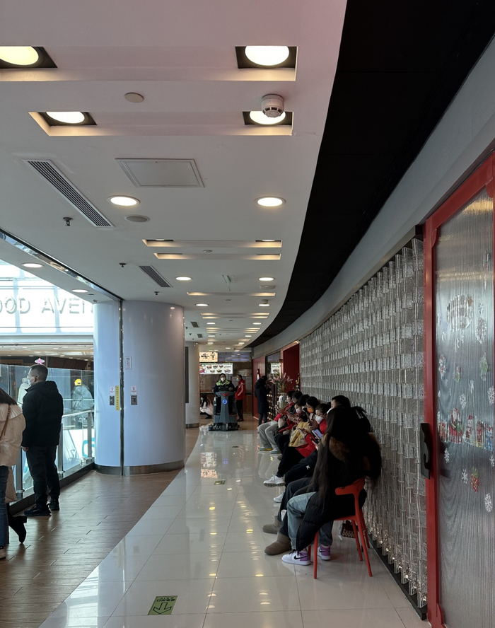 （一家川菜馆门口坐满了等位的食客&nbsp;摄影：孙璐璐）