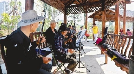        市民在新建成的口袋公园里休闲娱乐。资料片