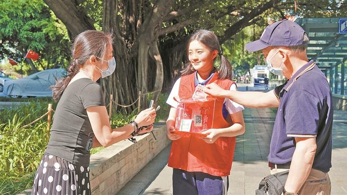 曾盈之（中）参加城市志愿服务U站的义卖活动。