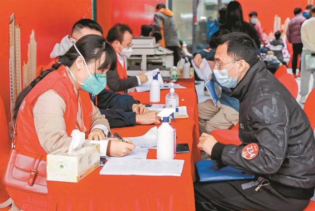 ▲交付现场，工作人员有序引导住户办理资料审核、缴费、领取钥匙、验房手续。受访单位供图