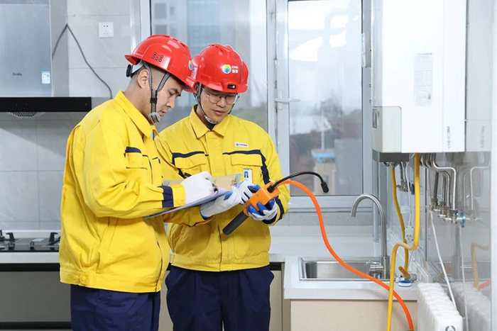 ▲新奥的工作人员在客户家中安装调试“智能厨房”物联设备