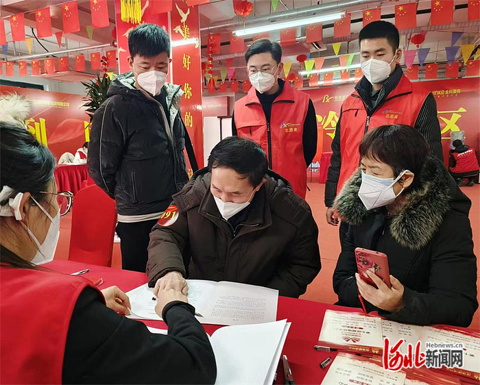 雄安新区容西管委会清泉社区社工王雅洁、史源昊陪同回迁业主办理交房手续。  王青峰摄