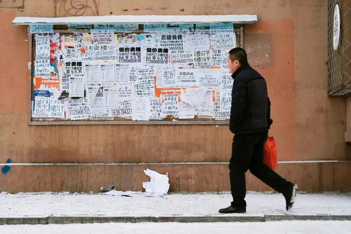 鹤岗的很多棚改小区内，都可见贴满的售楼广告。（宝丁 摄）