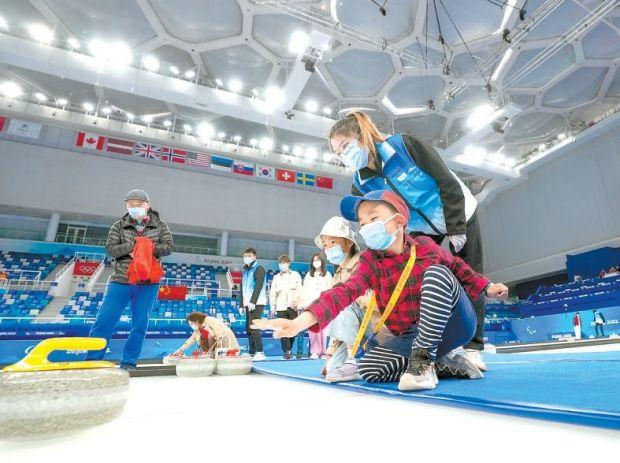 2022年4月，“冰立方”开放后，在教练的指导下，小朋友们体验在冬奥冰壶赛道上投壶。本报记者 武亦彬摄
