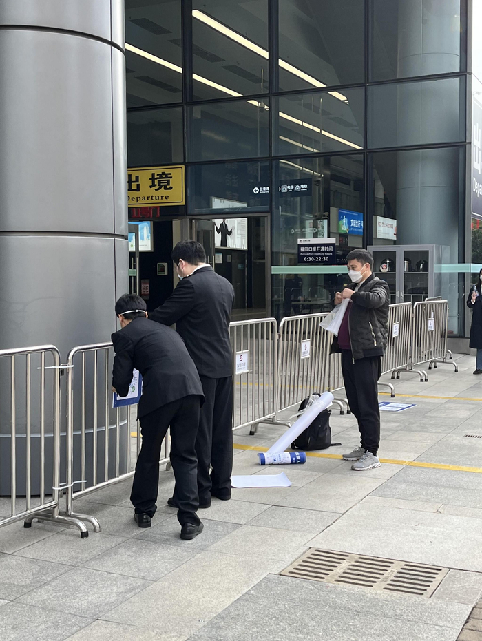 福田口岸工作人员在张贴出入境申报二维码 财联社记者摄