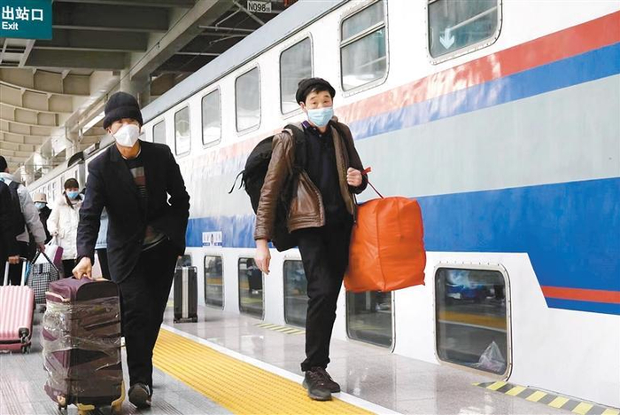 春运首日，旅客们带着行囊准备乘坐返乡的列车。（记者 翟小雪 摄）