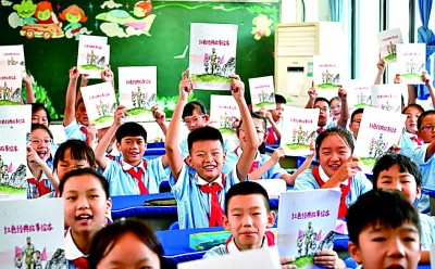     开学第一课上，九龙坡区的学生们展示红色故事读本新书，书中插画由川美一中教育集团的学生绘制。周舸摄