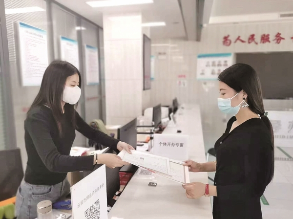工作人员在个体开办专窗为市民办理营业执照。