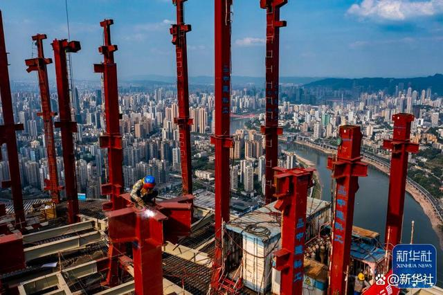 ↑2022年7月13日，施工人员在重庆陆海国际中心项目主塔楼楼顶进行焊接作业（无人机照片）。新华社记者 刘潺 摄
