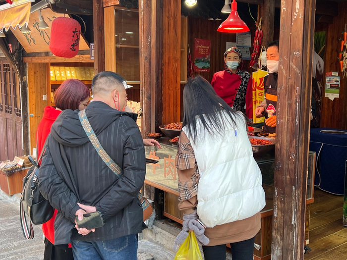 来自四川宜宾的游客刘忠兵正在购买牛肉干